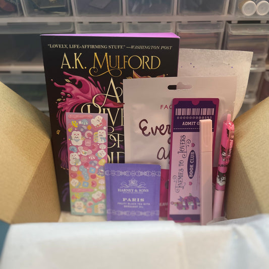 Collection of small items including books and stationery on a white surface with a blurred background.